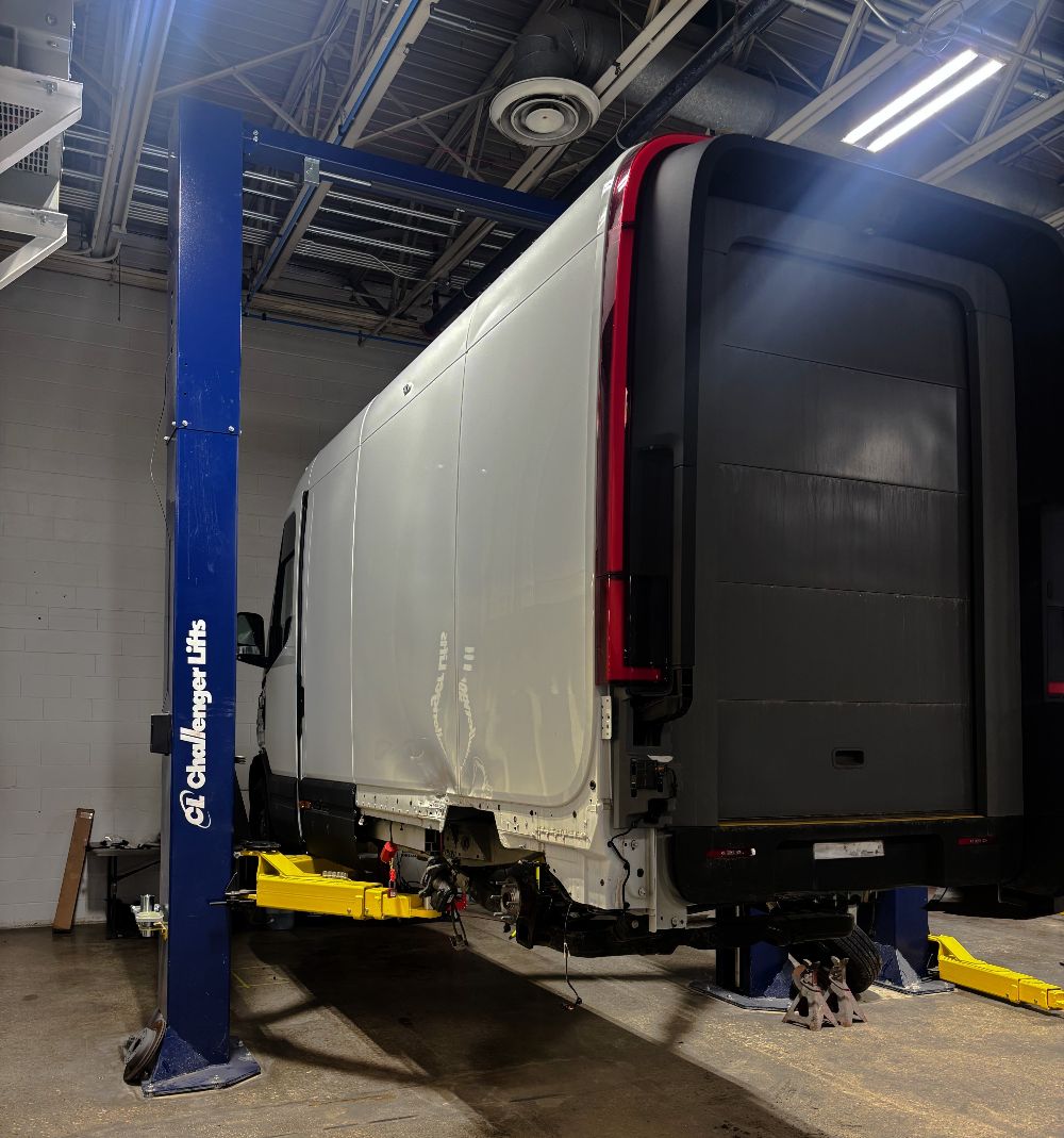 EV Delivery van on challenger lift - Axelrod Truck and Fleet Collision Repair